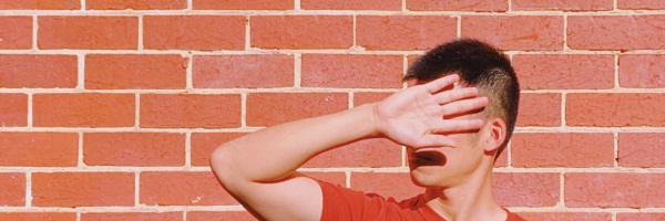 man blocking face with hand